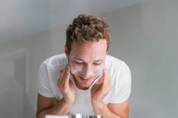 Ausschnitt einer jungen Frau mit unreiner Haut bei der Feuchtigkeitspflege fürs Gesicht